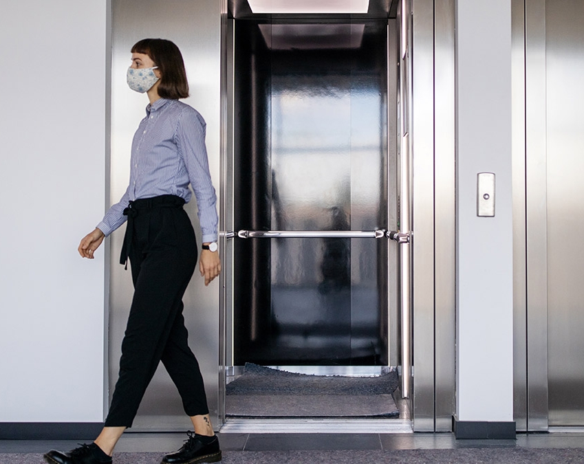 Ascenseur Otis avec femme portant un masque